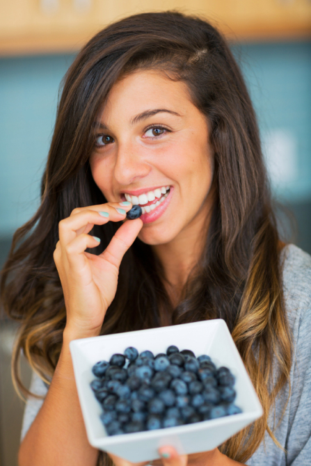 Beautiful woman eating blueberries, Healthy Food Lifestyle